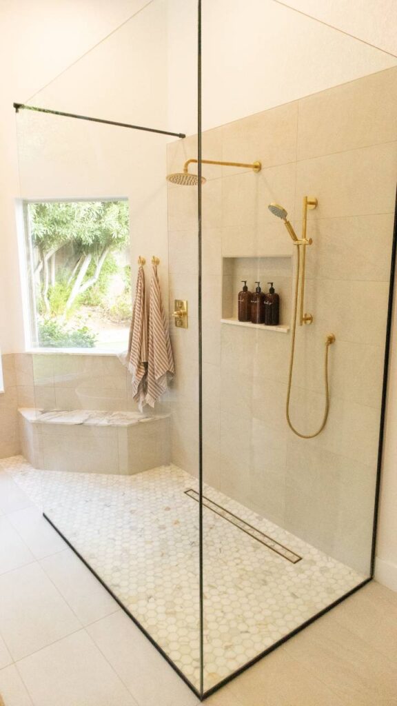 Shower with multiple shower heads, bench and window
